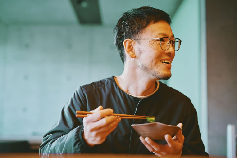 『西阪農園』西阪正和さんが菊菜の和え物を食べる様子