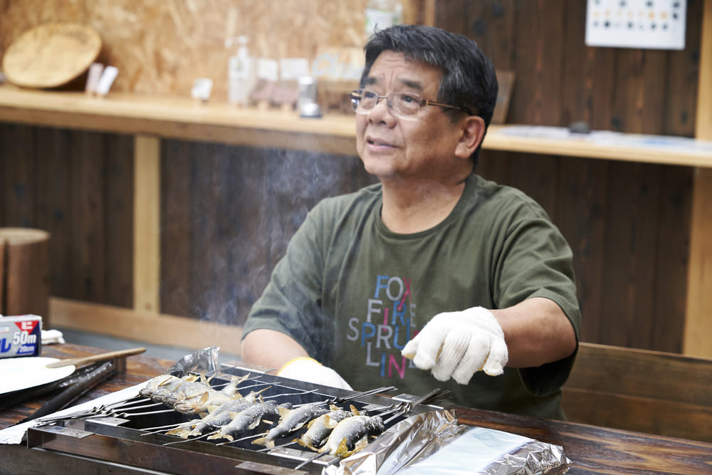 鮎を塩焼きにする坂本靖彦さん