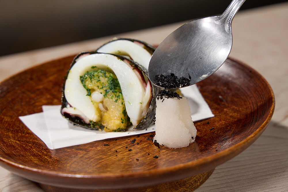 大根おろしにイカ墨パウダーをかける